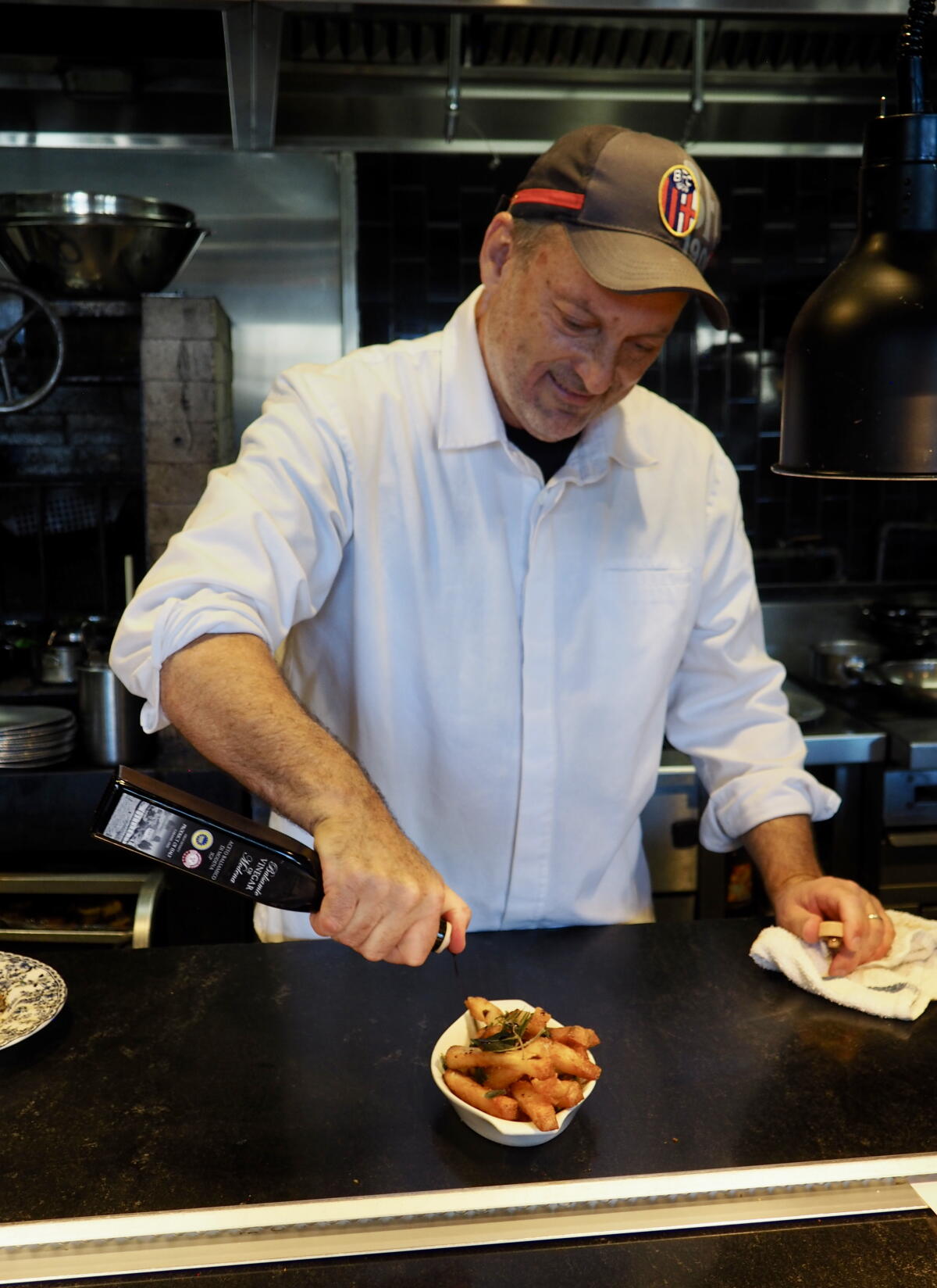 Chef Steve Samson prepares an order of French fries at his downtown restaurant Rossoblu.