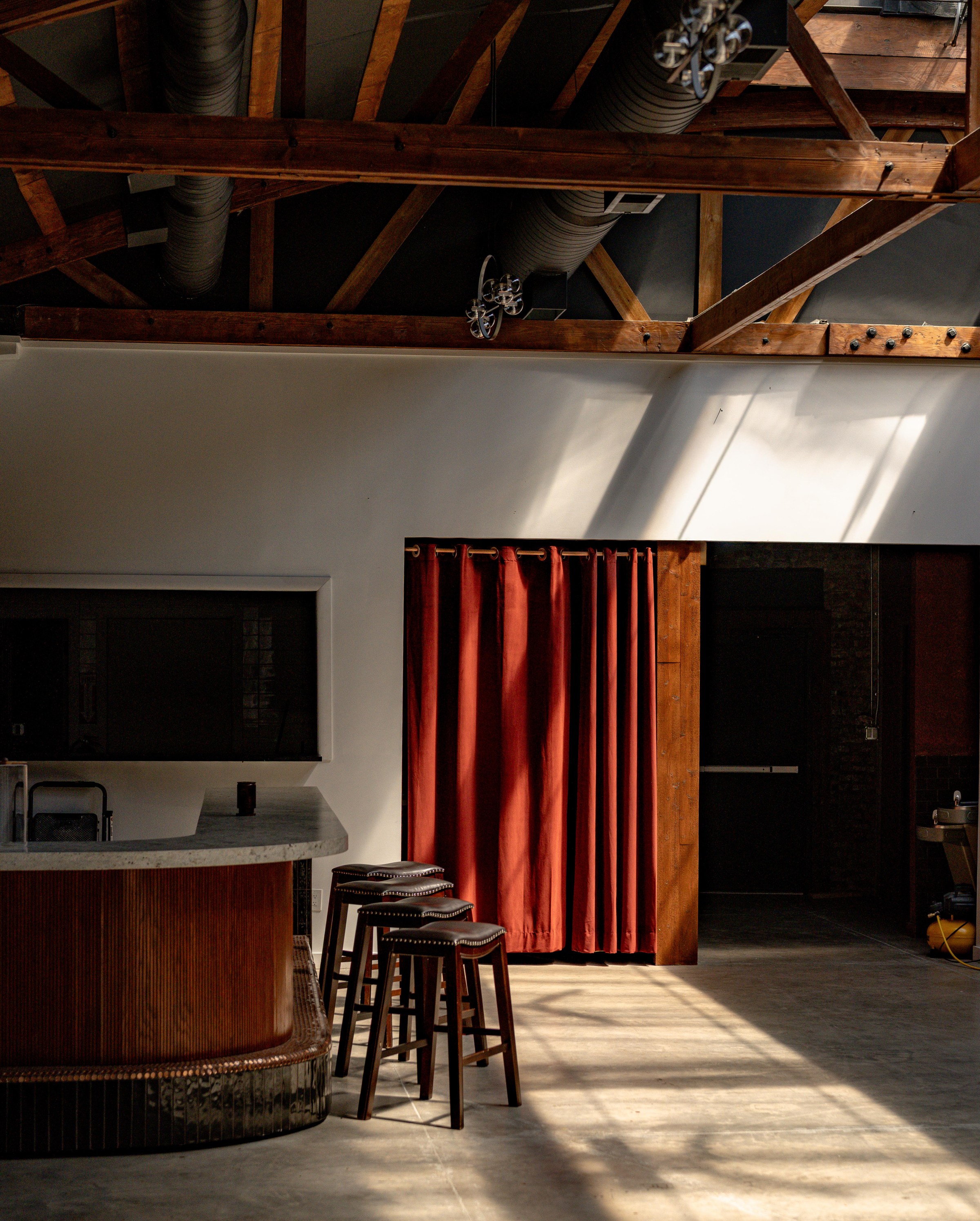 A red curtain next to a small corner bar.