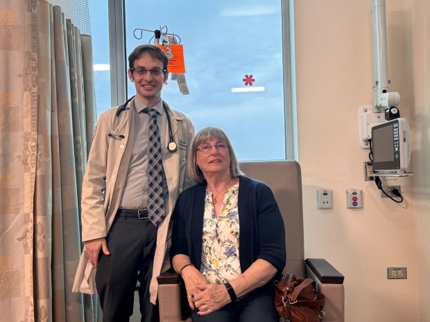 Dr. Ari Seifter gathers with his patient Karen Daggett in the infusion room at South Suburban Hospital in Hazel Crest. Daggett was treated for melanoma under her right armpit, which she said was discovered after family dog Zeki pointed it out. (Advocate Health Care)