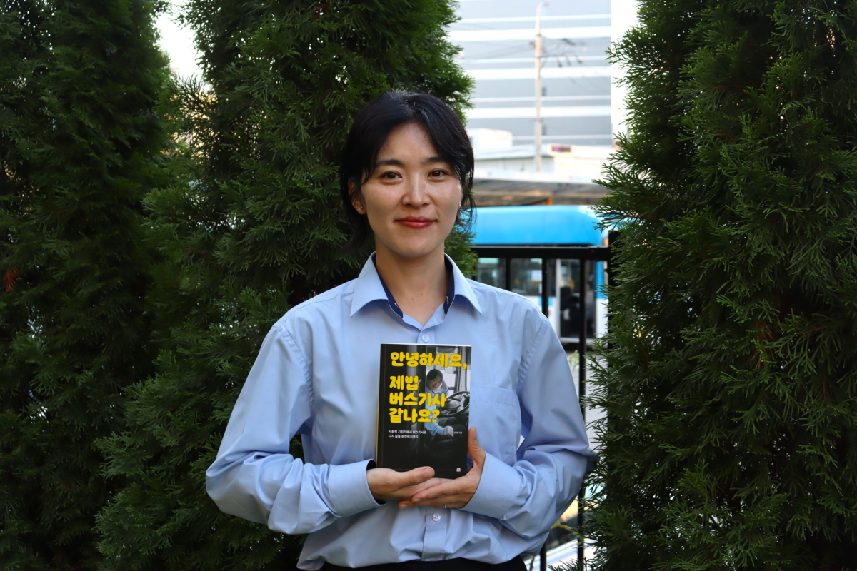 Kang Hee-jung, photographed at a bus depot in Anyang, holds her essay collection "Hello, Do I Look Like a Real Bus Driver Yet?" Kim Su-ho - Seoul Economic Daily Society News from South Korea