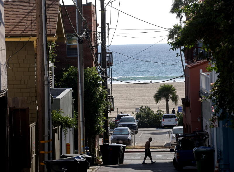 A man walks across an alley about a block away from the Seychelle Condominiums.