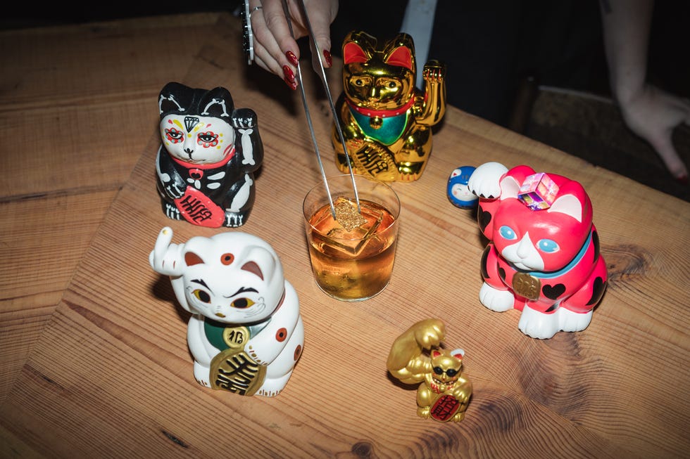 Ceramic figurines around a drink with a decorative ice cube.